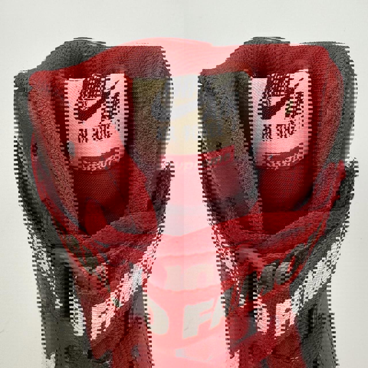 Supreme x Nike Air Force 1 High World Famous sneakers in red.